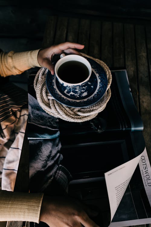 Free Woman reading magazine while having hot beverage Stock Photo