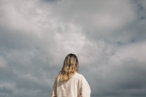 Woman enjoying cloudy sky at sunset