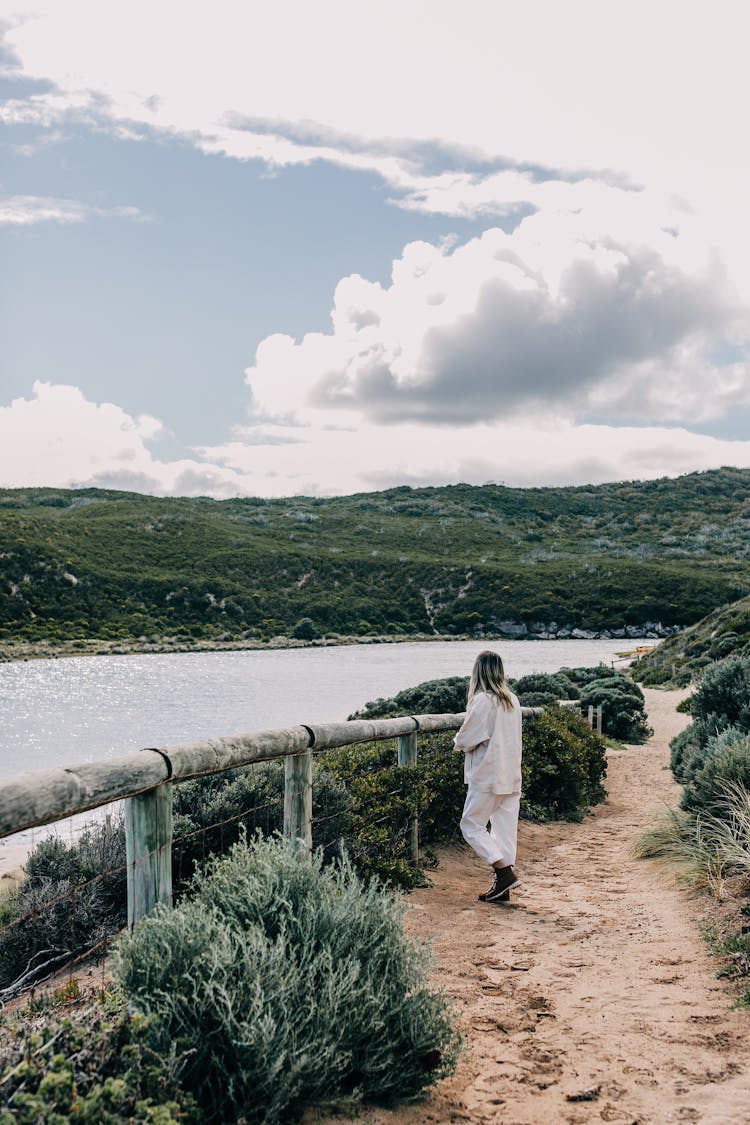 Woman Walking On Pathway Near River