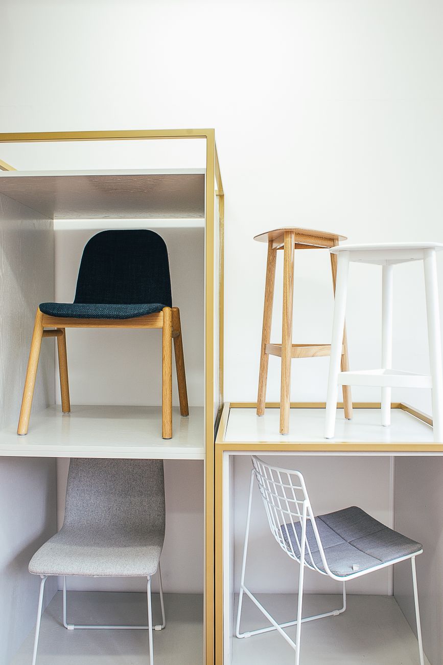 Chairs placed near a white wall in a light-filled room, exploring form and material variety.