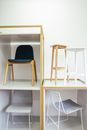 Abstract interior of room with white wall and various chairs placed in boxes and near each other