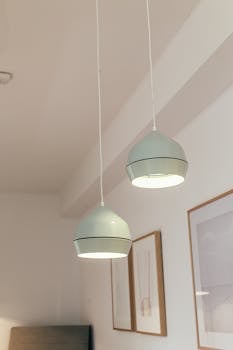 A minimalist interior featuring modern white pendant lamps and framed artworks.