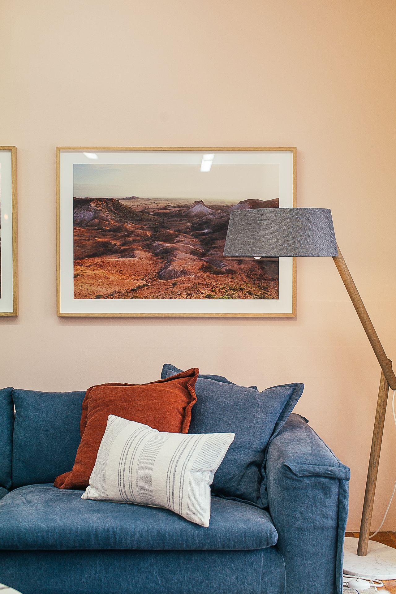 Sofa and lamp in an apartment with pictures hung on the wall