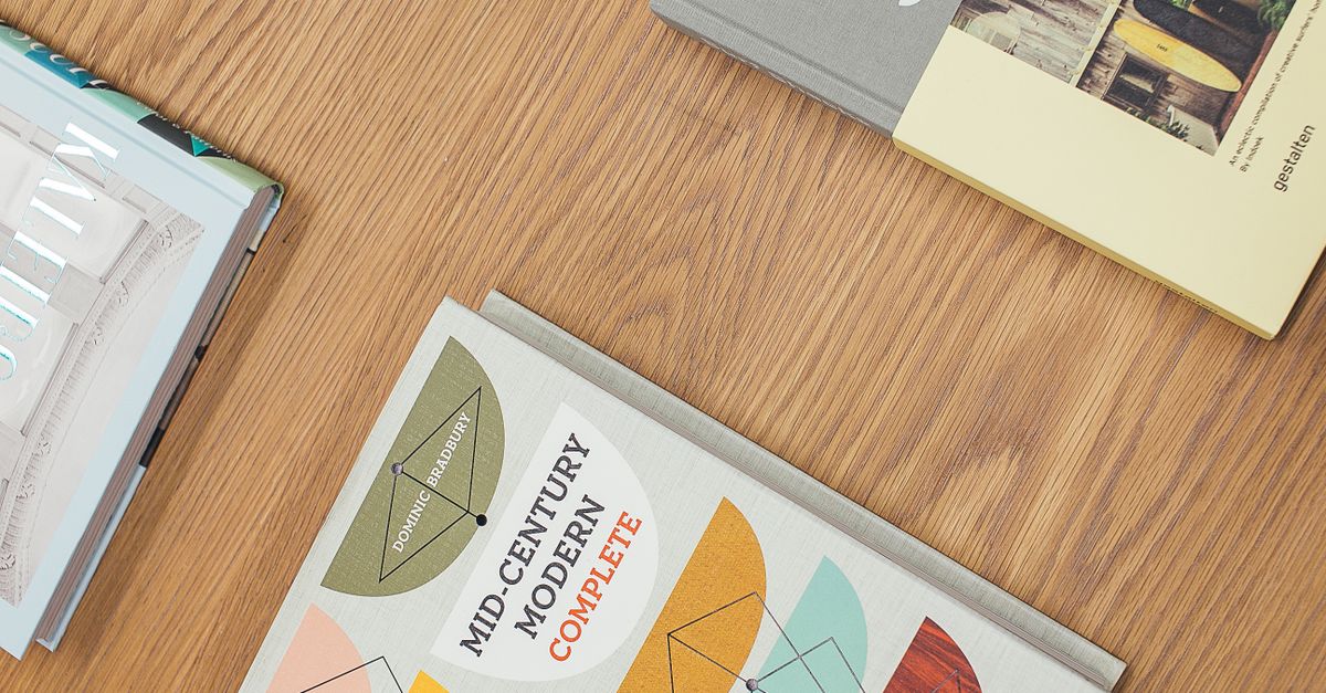 Top view of various hardcover books stylishly arranged on a wooden tabletop.