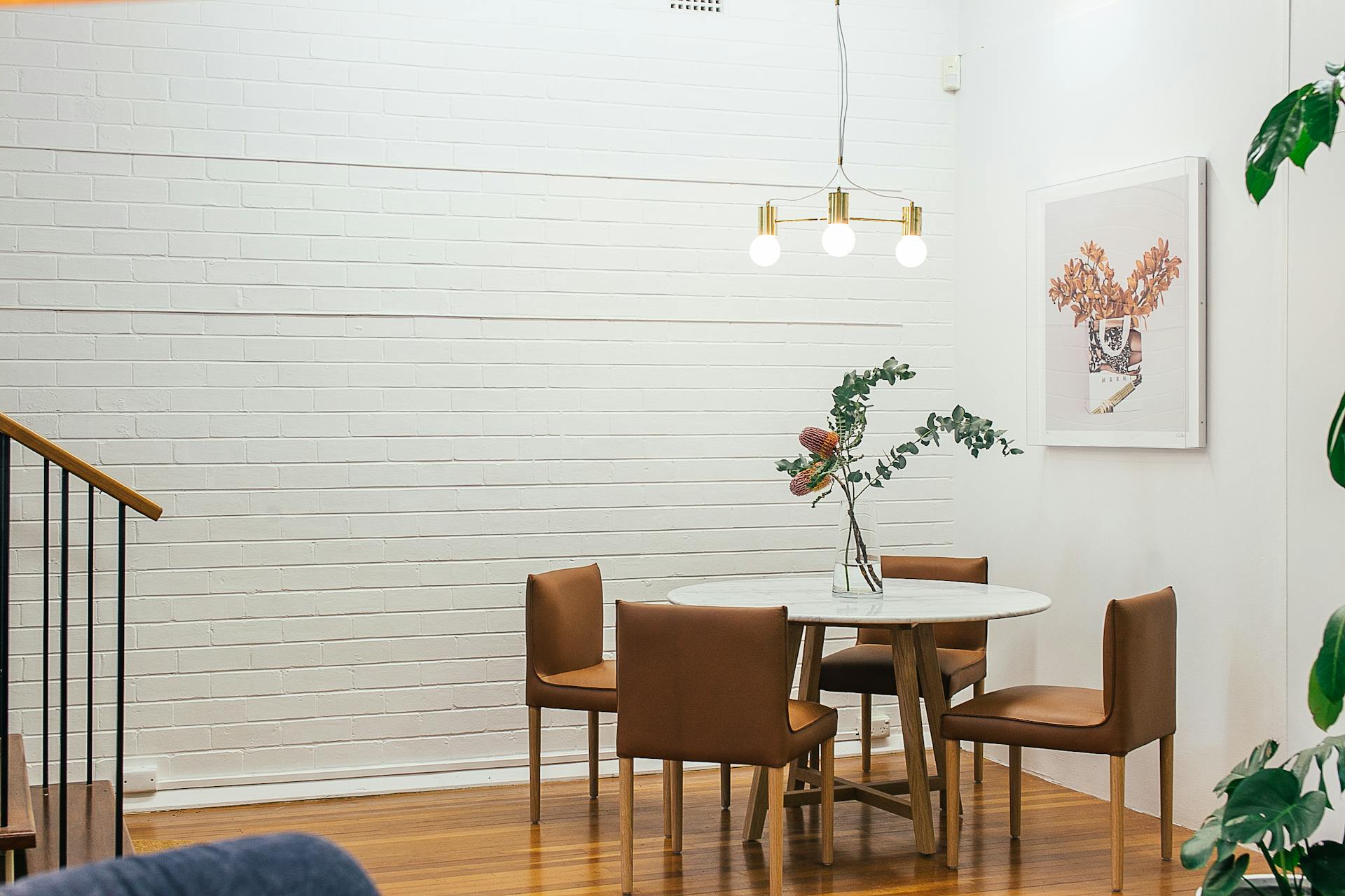 Table with vase near chairs and painting