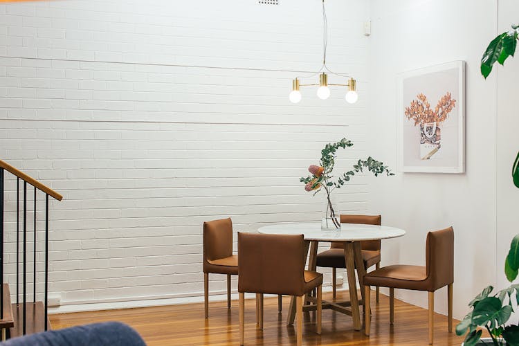 Table With Vase Near Chairs And Painting