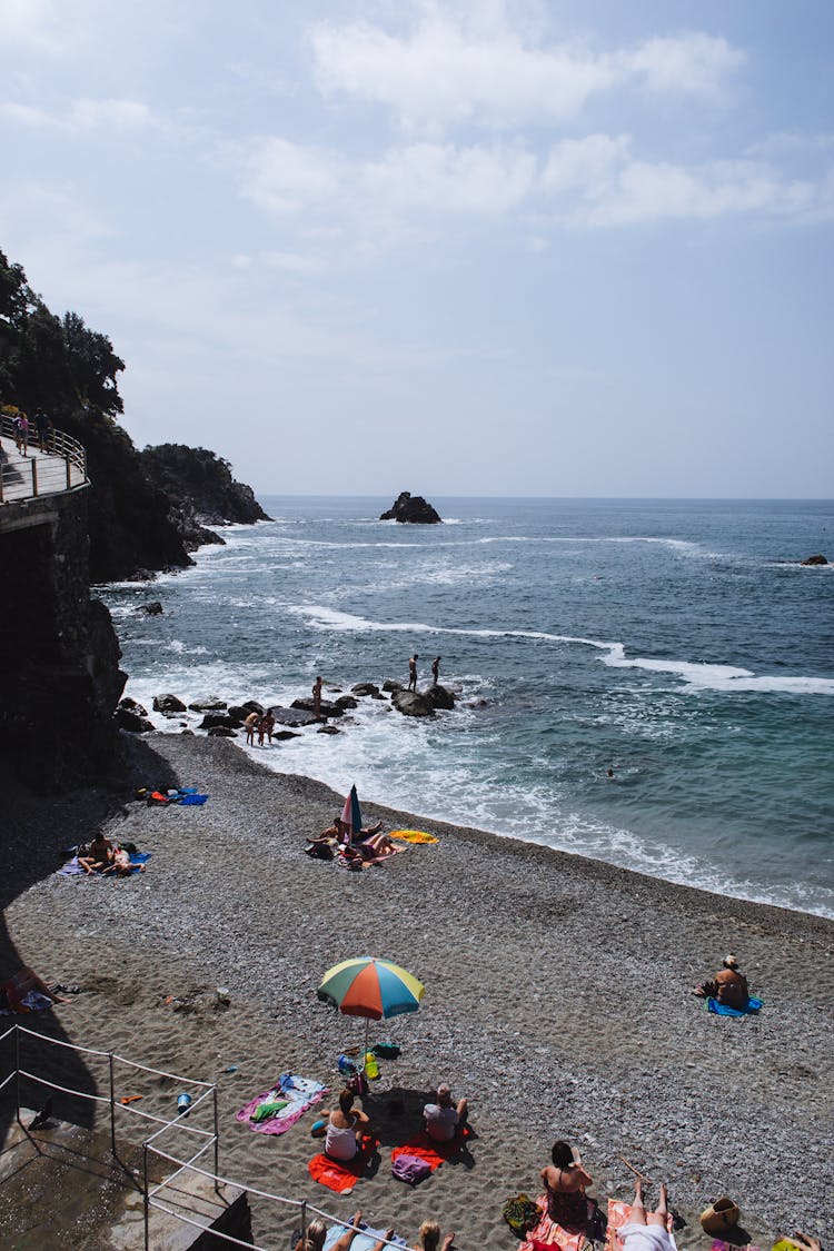 People Relaxing On Sandy Beach