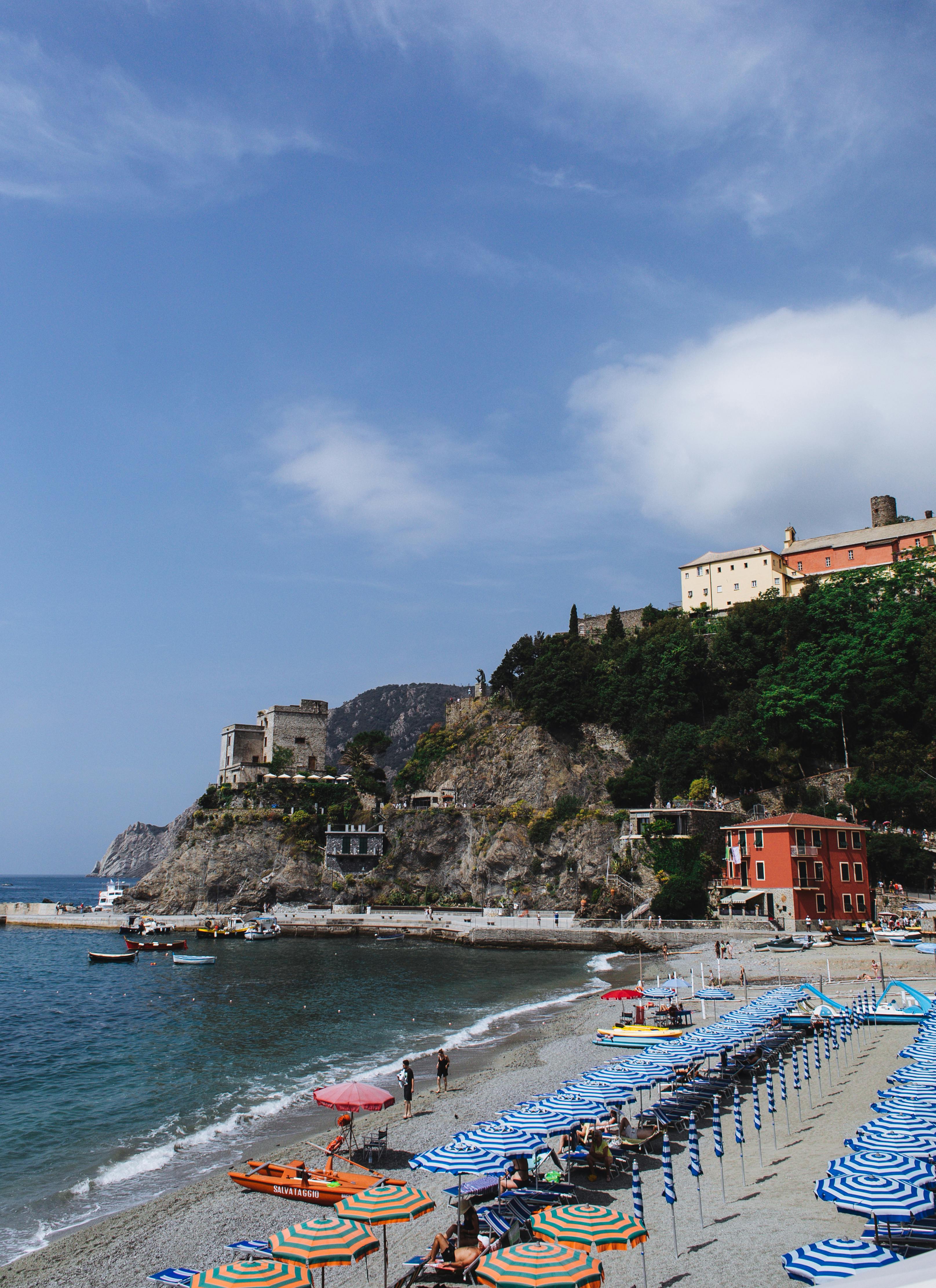 从沙滩上方的日光浴人群、日光浴床和阳伞附近，海水轻轻荡漾