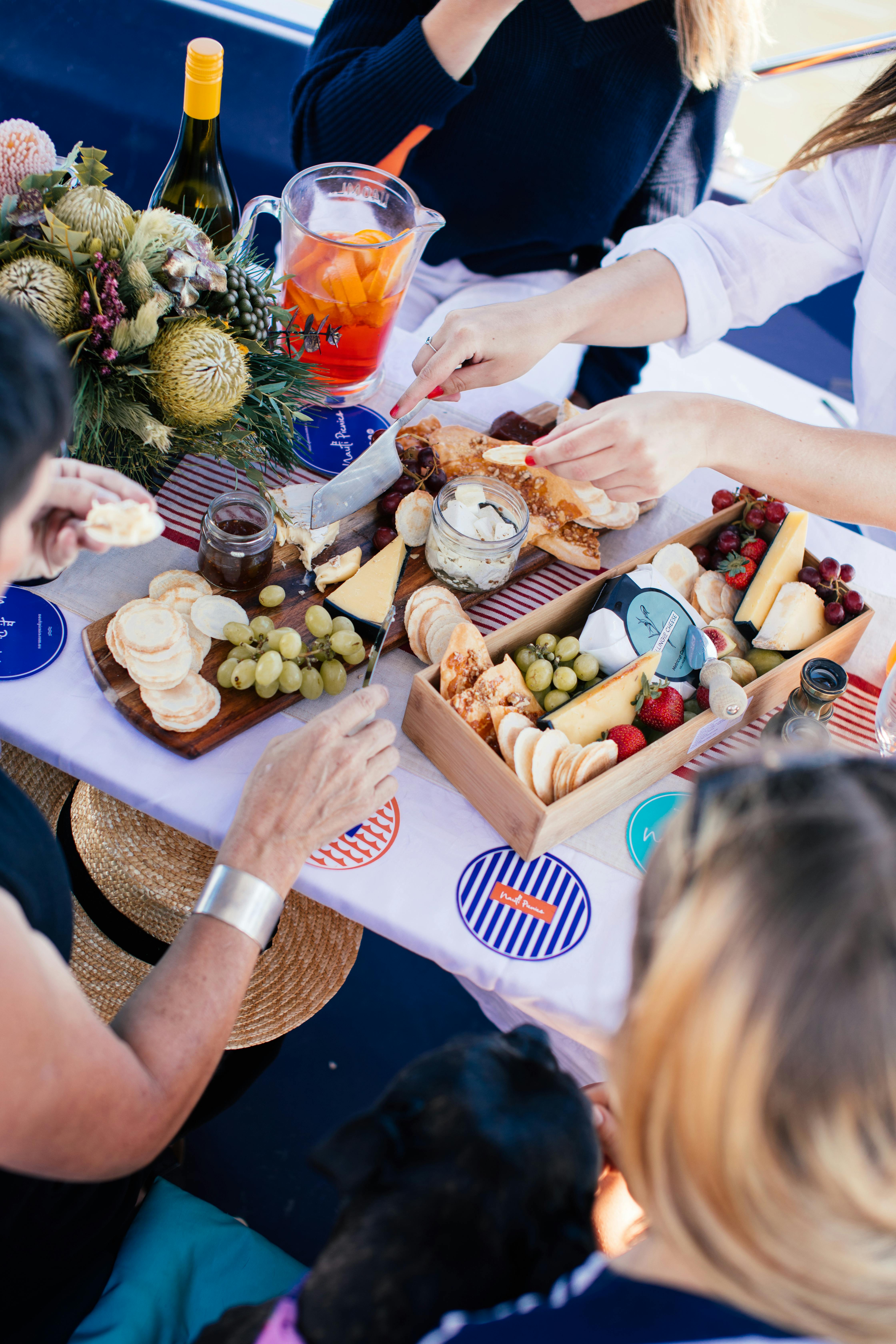 crop people having picnic with drinks and food