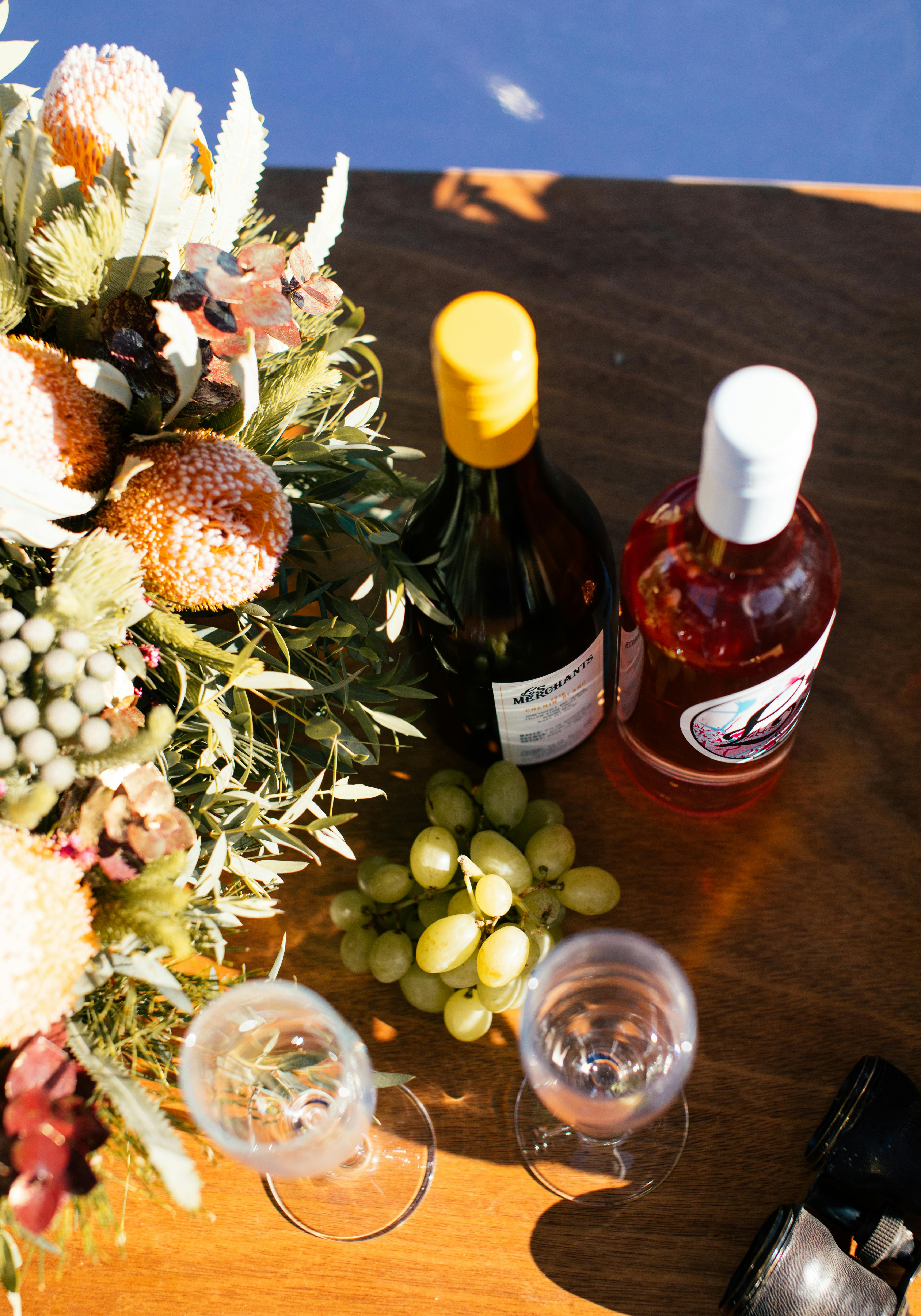 bottles with alcoholic drinks and grapes