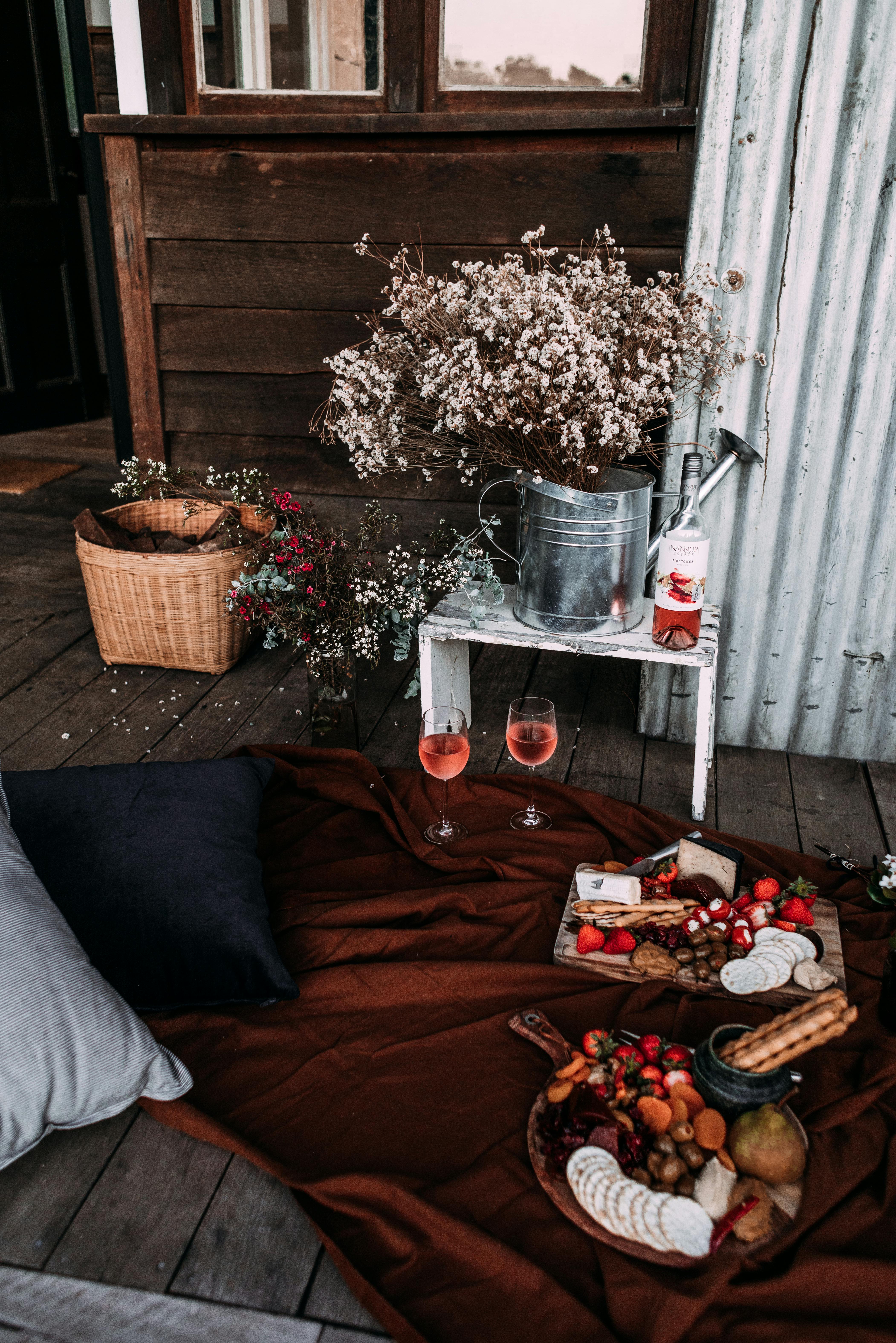 High angle of cozy place prepared for romantic date with wine and snacks on soft plaid