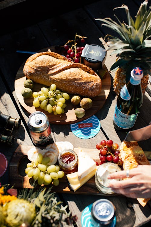 Free Crop person at table with assorted appetizers and beverages Stock Photo