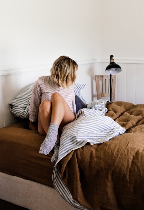 Free Unrecognizable woman on cozy bed in house Stock Photo