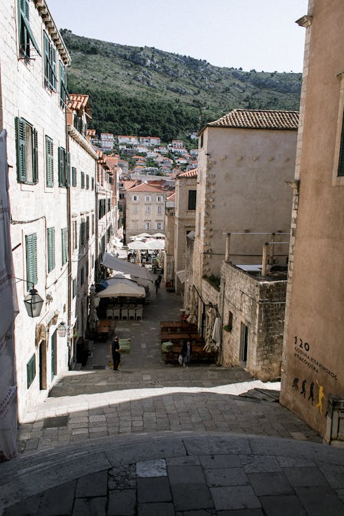 Pathway between old residential houses against ridge in town