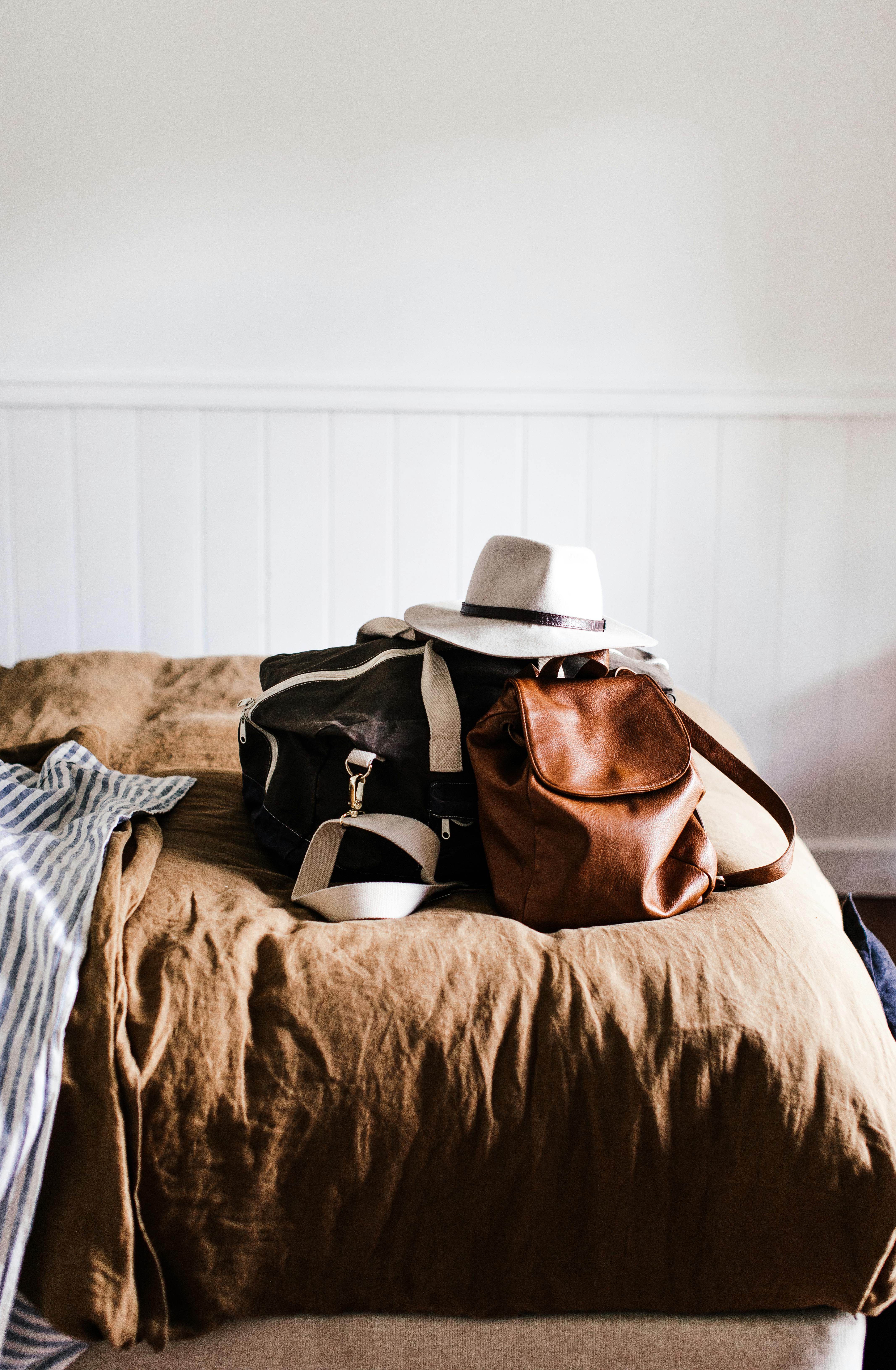 baggage with hat on soft bed in house