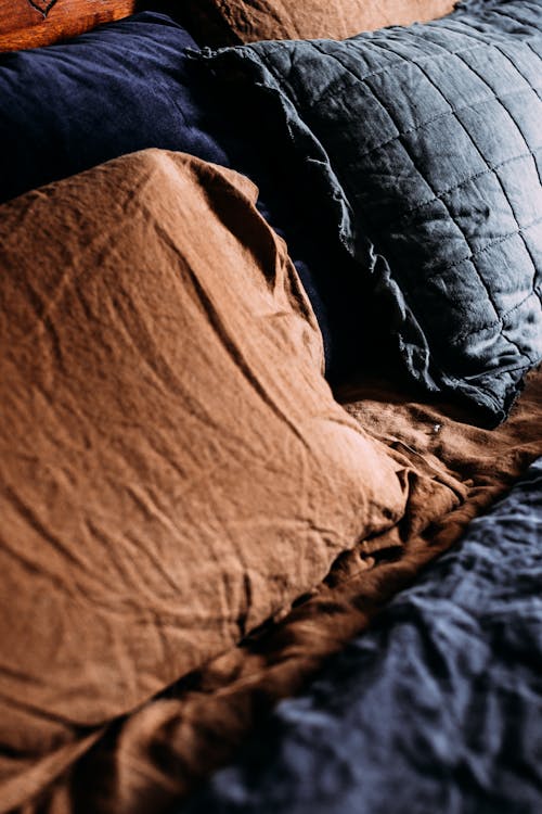 Decorative cushions on crumpled bed sheet at home