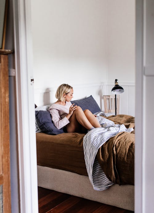 Relaxed woman in soft bed at home