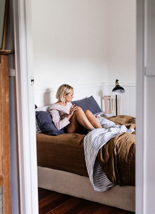 Free Relaxed woman in soft bed at home Stock Photo