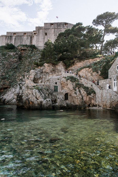 Scenery view of old masonry constructions on mount against Adriatic Sea with pure water in Dubrovnik Croatia