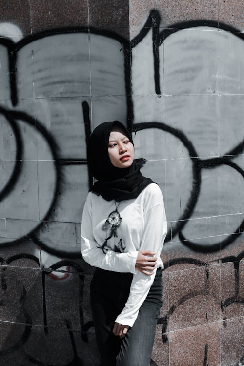 Young Woman in Hijab Posing on Graffiti Wall