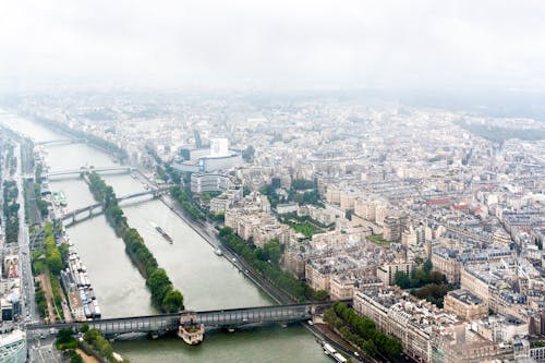 Free Amazing aerial view of bridges over Seine river flowing amidst residential districts with historical buildings in Paris Stock Photo