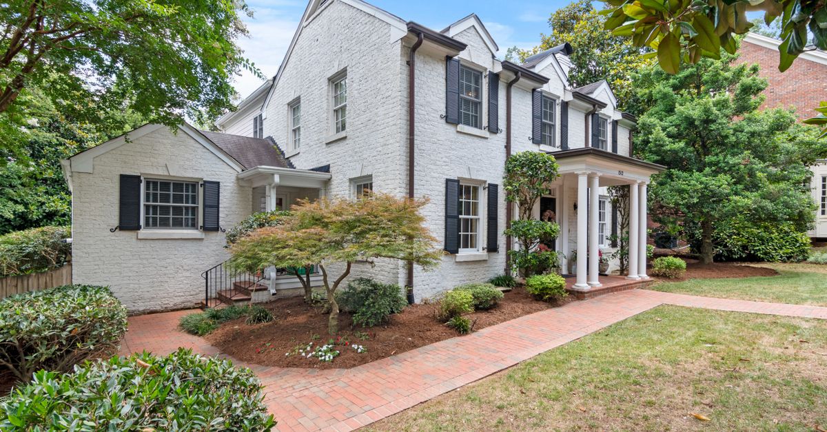 Elegant suburban house with brick facade and lush garden, perfect for serene living.