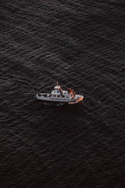 Aerial view of yacht sailing on wavy ocean water during travel in daytime