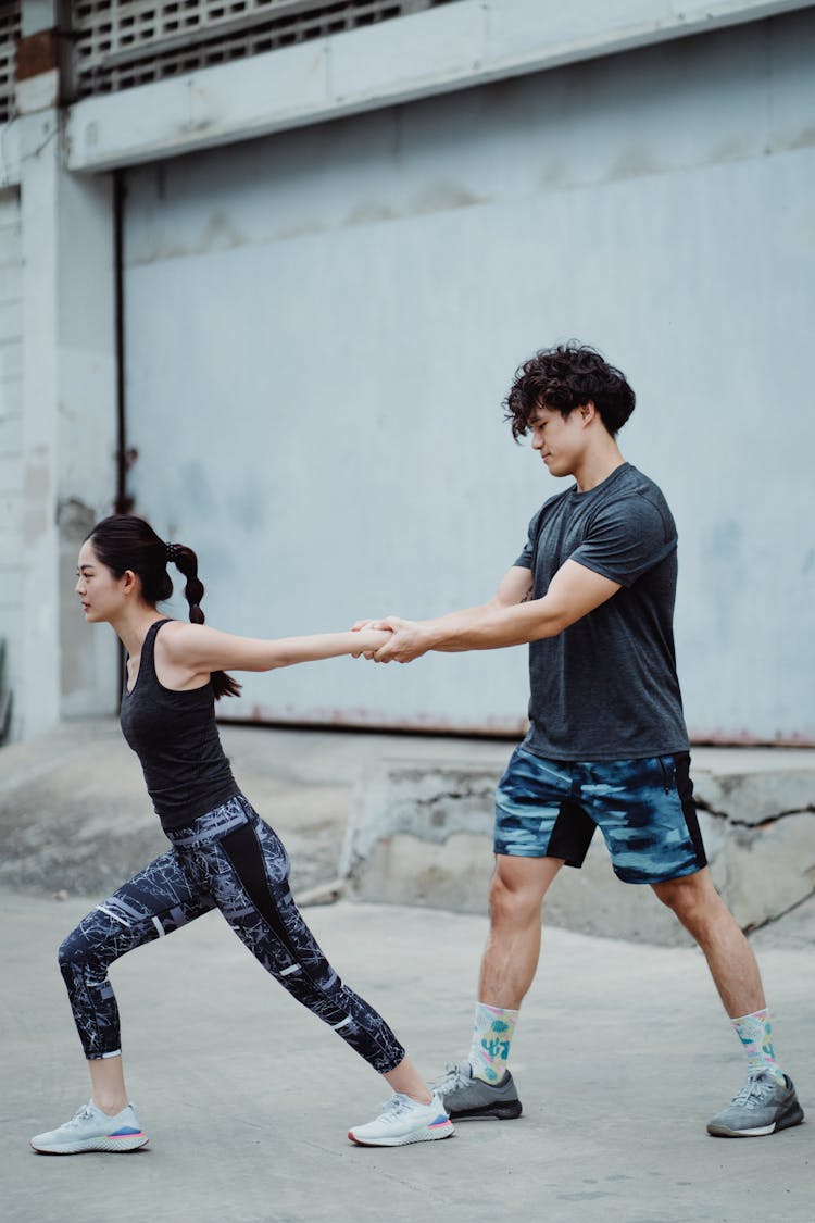 Couple In Sportswear Training Together Outside