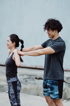 A young couple exercising outdoors, having fun and supporting each other