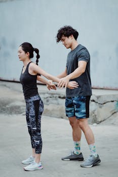 A man and woman stretching together outdoors, promoting fitness and teamwork.