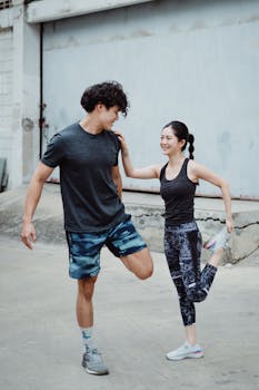 Man and woman stretching outdoors before a workout session.