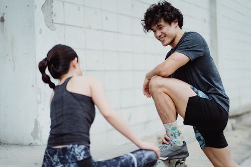 Free A man and woman interacting during an outdoor workout session, promoting healthy lifestyle. Stock Photo