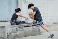 Man in Black T-shirt and Blue Denim Jeans Sitting on Concrete Wall