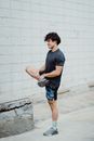 Man in Blue Crew Neck T-shirt and Blue Denim Shorts Standing on Gray Concrete Floor
