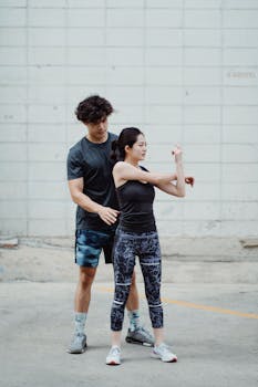 A couple stretches together outdoors in athletic wear, promoting health and fitness.