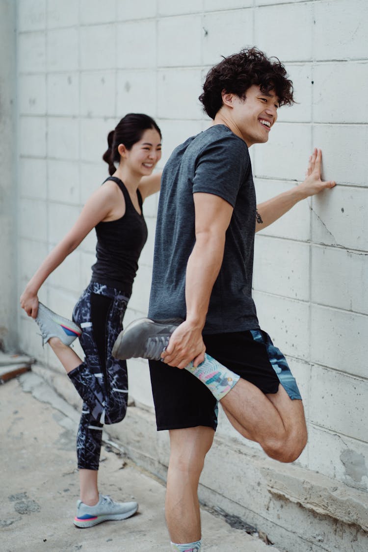 Smiling Young Couple Training Outside Together