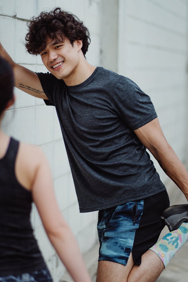 Smiling Young Man In Sportswear Training Outside