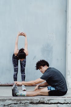 A man and woman performing stretching exercises, promoting health and flexibility.