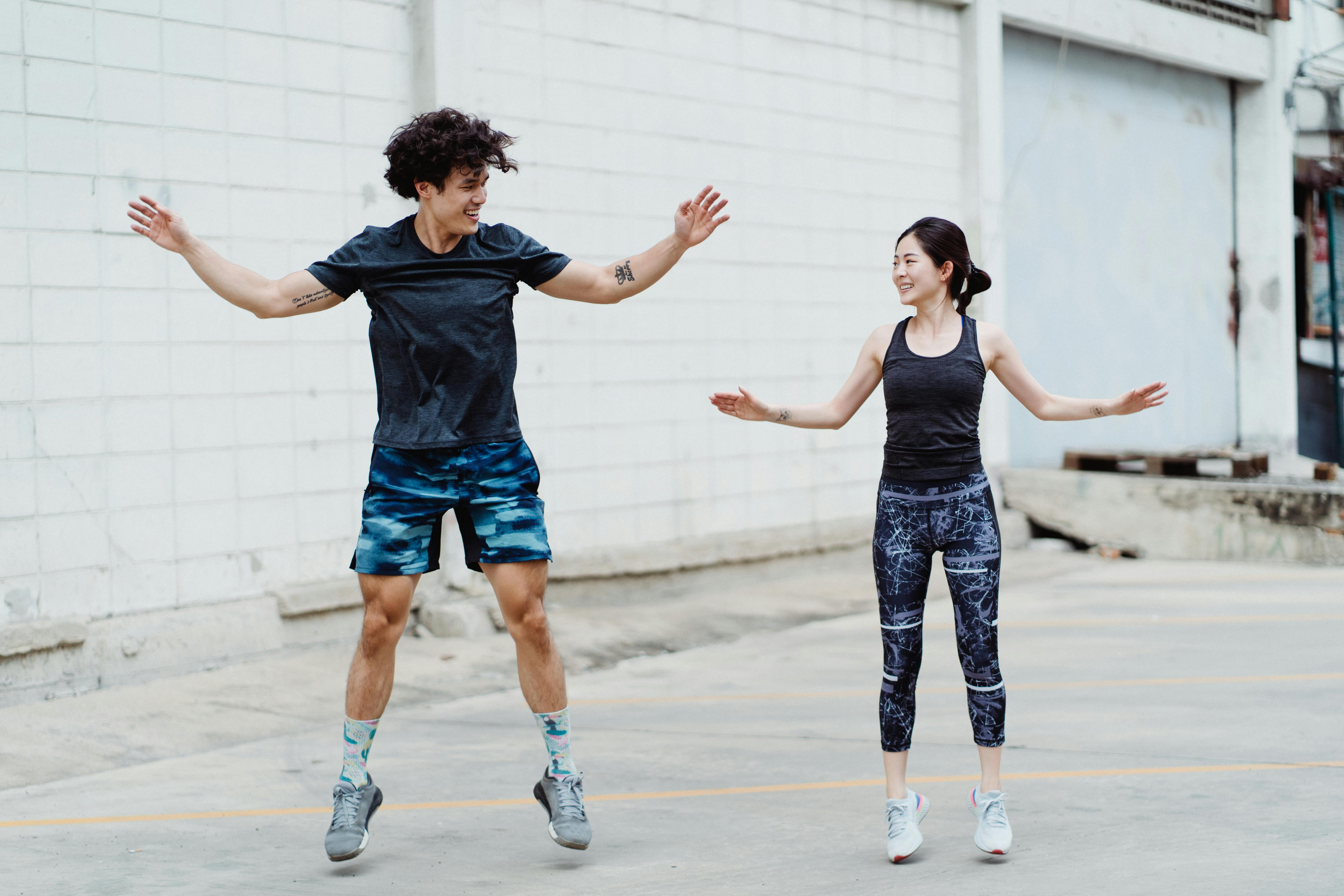 两名成年人在户外进行有趣的健身锻炼，展现了活力与健康的生活方式