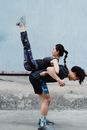 Woman in Black Shirt and Blue Shorts Carrying Girl in Black Shirt