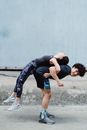 一对夫妇在户外锻炼时玩得很开心，展现了健身与团队合作