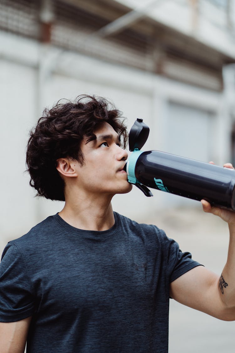 A Man Drinking From A Tumbler