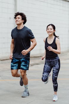 Happy couple jogging outdoors in trendy activewear, promoting fitness and lifestyle.