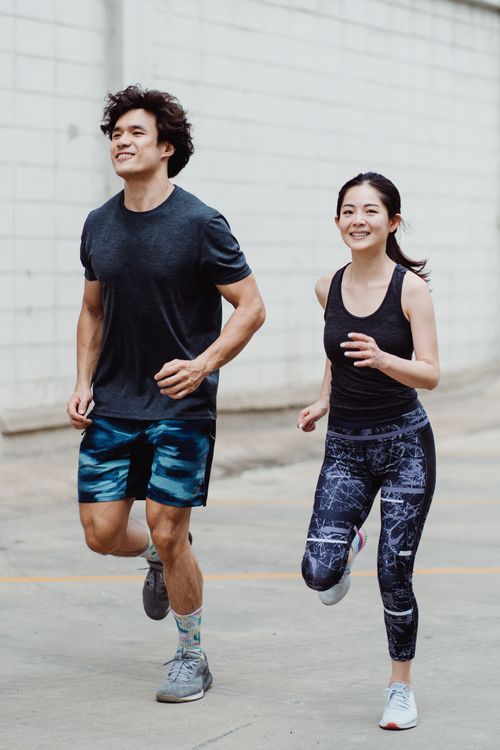 Free Happy couple jogging outdoors in trendy activewear, promoting fitness and lifestyle. Stock Photo