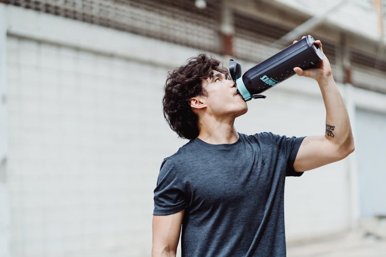 A Man Drinking From A Tumbler