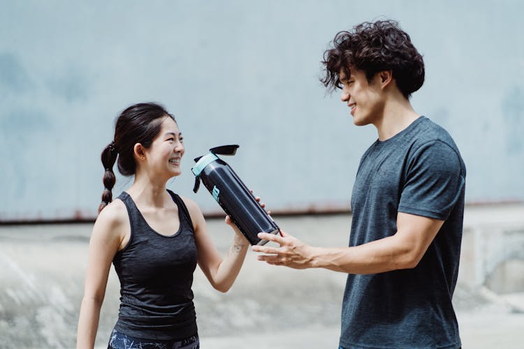 Happy People Drinking Water After Training 