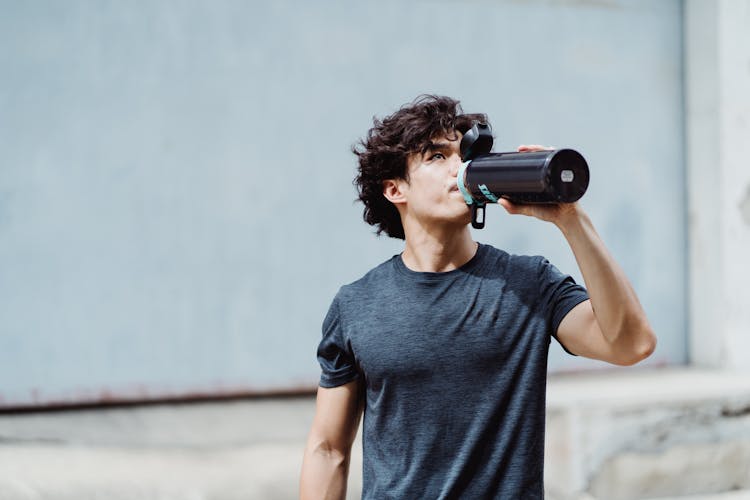 Portrait Of Man Drinking After Workout