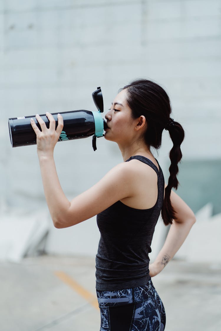 Thirsty Woman Drinking After Workout