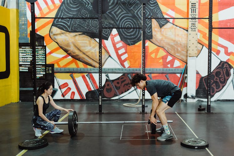 Man And Woman Exercise Together With Weight