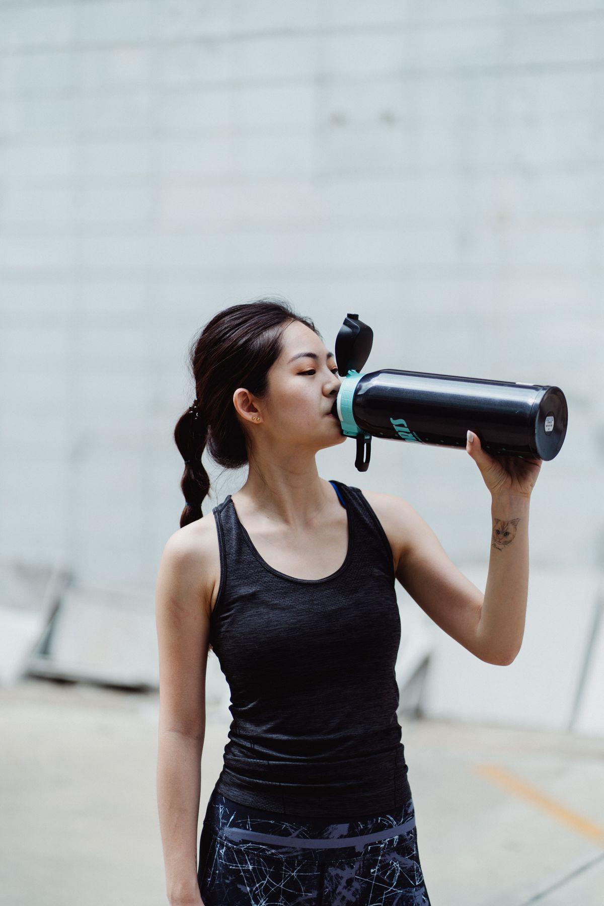 Woman drinking water after being active outdoors